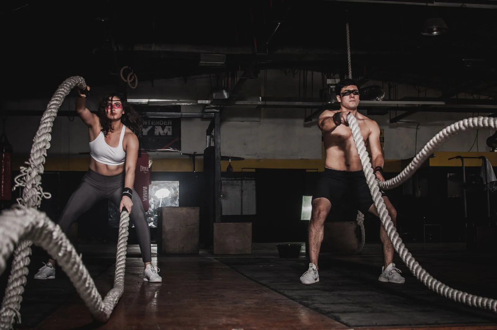 Two people training with battle ropes in the studio